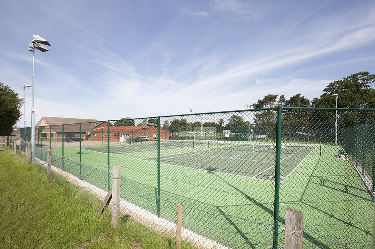 Tennis court after fence upgrade and floodlight installation